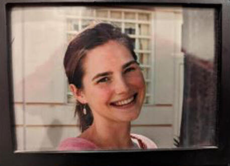 Meredith: foto Knox in carcere, sorriso e sbarre su sfondo